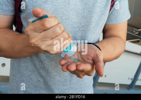 Man washing hands and applying alcohol gel to clean and get rid of germ, bacteria at train station. Health care and infection control concept Stock Photo