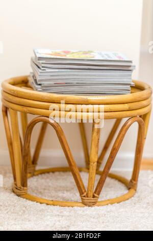 Still life detail of living room with a bamboo texture coffee table and a pile of books and magazines, home living room interior. - Image Stock Photo