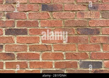 a colorful and beautiful retro red brick and sand grout garden wall close-up Stock Photo