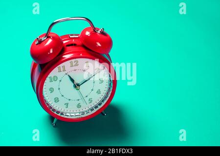 Red alarm clock on the color background. Stock Photo