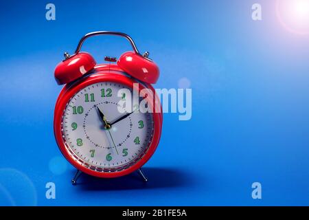 Red alarm clock on the color background. Stock Photo