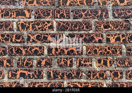a beautiful peeling weathered aged vintage painted red brick wall close-up Stock Photo
