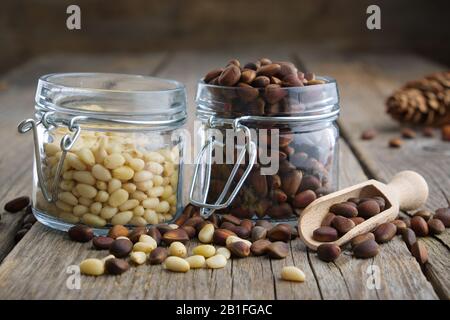 Pine nuts. Jars of cedar pine nuts on table. Stock Photo