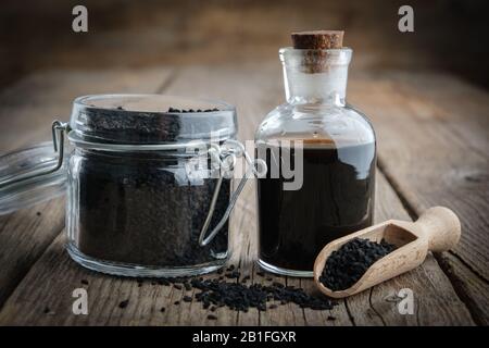 Jar of black cumin or roman coriander seeds and black caraway oil bottle. Ingredients for cooking. Ayurveda natural treatments. Stock Photo