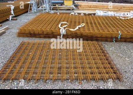 a stack of rusty brown steel mesh mats are lying on a building site Stock Photo