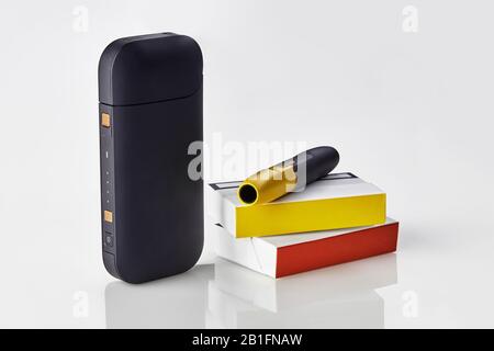 New generation black electronic cigarette is on packs with red and yellow  sides, battery, isolated on white. New technology. Heating tobacco system.  T Stock Photo - Alamy