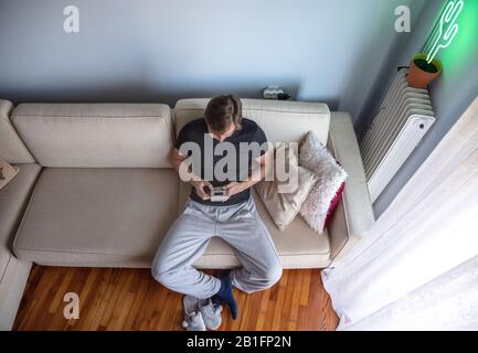 Man playing Game Boy at home. Stock Photo