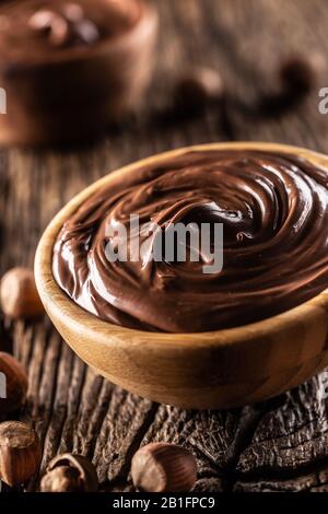 Chocolate hazelnut spread in wooden bowl - Close up. Stock Photo