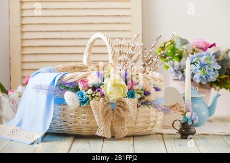 Multicolored Easter wicker basket on a wood background Stock Photo