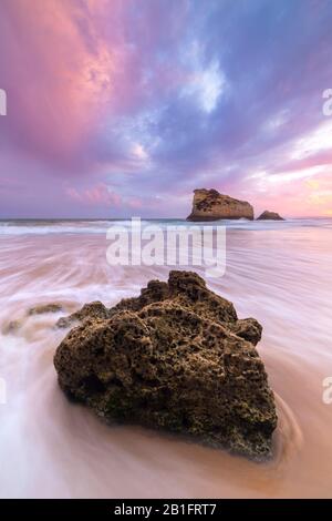 A colorful sunset reflected on the wet shores of Praia Dos Tres Irmaos. Alvor, Portimao, Algarve, Portugal,Europe. Stock Photo