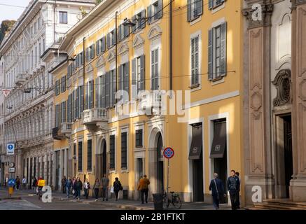 Classical old buildings with shutters and balconies along Via Alessandro Manzoni in Milan, Lombardy, Italy Stock Photo