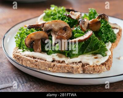 Mushrooms and Kale with Vegan Ricotta on Toast Stock Photo