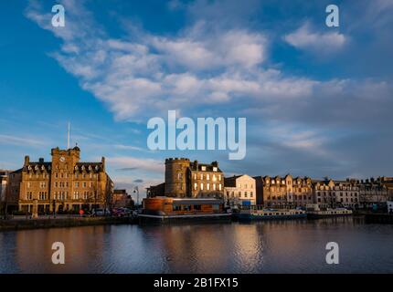 Leith, Edinburgh, Scotland, United Kingdom. 25th Feb, 2020. UK Weather: Sunshine at dusk lights up the old buildings, including the Malmaison Hotel (former Seamen's Mission) on The Shore which are reflected in the Water of Leith Stock Photo