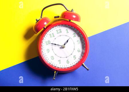 Red alarm clock is on color background. Time concept Stock Photo