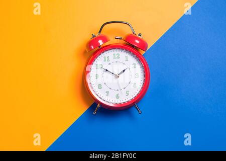 Red alarm clock is on color background. Time concept Stock Photo