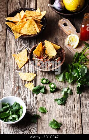 Homemade salsa and tortilla chips, favorite Mexican appetizer snack on rural wooden table, close up Stock Photo