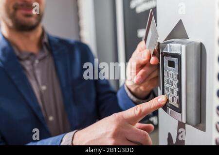 Man hand pressing the security code combination and using key card to unlock the door Stock Photo