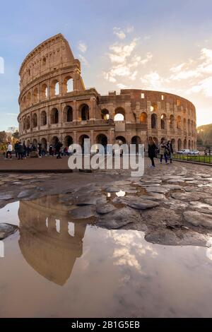 View of the Colosseum reflecting on a puddle during a winter sunrise. Rome, Lazio, Italy. Stock Photo