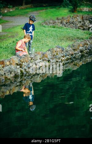Lviv, Ukraine - June 23, 2019: kids with fish net looking tadpole in