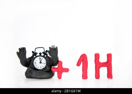 Funny clocks made from Play Clay. Isolated on white background.  Daylight Saving Time concept. Stock Photo