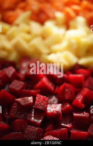 Square raw sliced beets, potatoes and carrots in three rows background. Side view closeup Stock Photo