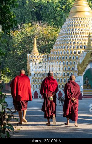 Buddhist monks walking in early morning light, Amarapura, Mandalay Region, Myanmar Stock Photo