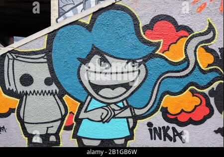 Modern graffiti in Porta Garibaldi distrect of Milan, Italy, depicting caricatures of young people smiling Stock Photo
