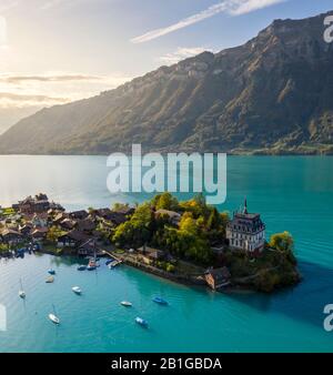 Aerial view of the village of Iseltwald and it's peninsula with the old Castle during an autumnal sunset on Lake Brienz. Stock Photo