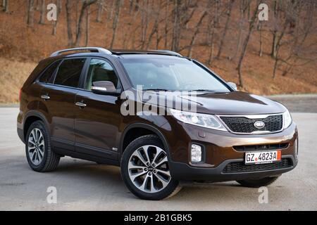 Kia Sorento Platinum equipment, facelift model, year 2014, mocca brown metallic colour. 4x4 family suv isolated in an empty parking lot, photo session Stock Photo