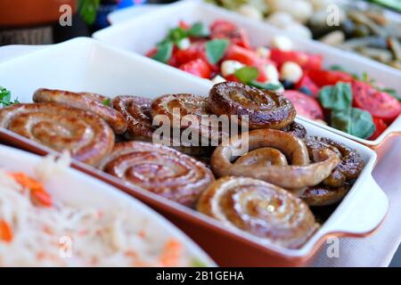 Fried round sausages in food market on the street.Street food and outdoor cooking concept Stock Photo