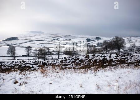 Snowy day in Wensleydale, Yorkshire Dales. Snow covers the hills and dry stone walls on a winter day near Hawes. Stock Photo