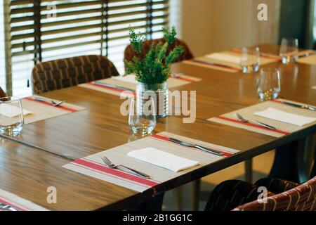 casual restaurant dining table set up, with dark brown color them Stock Photo