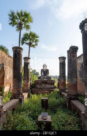 Buddha statue in midst of temple ruins, Yedansimi Pagoda, Inwa, Mandalay Region, Myanmar Stock Photo