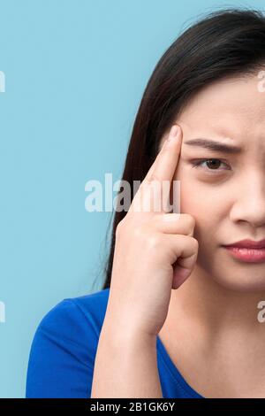 Freestyle. Chinese woman standing isolated on grey having headache wincing unhappy close-up Stock Photo