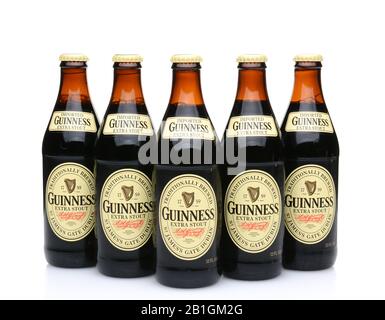 IRVINE, CA - MAY 27, 2014: Five bottles of Guinness Extra Stout on white. The Irish beer is one of the worlds most successful beer brands with annual Stock Photo