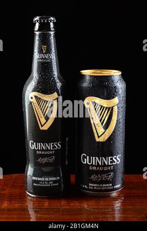 IRVINE, CA - JUNE 18, 2015: A bottle and can of Guinness Draught on a wet bar. Guinness producing beer in Ireland since 1759, is one of the most succe Stock Photo