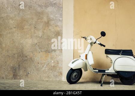 Nostalgic italian scooter in beige color against a beige wall Stock Photo