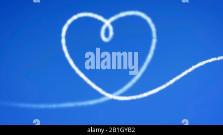 Heart shaped condensation trail against a cloudless blue sky - declaration of love Stock Photo