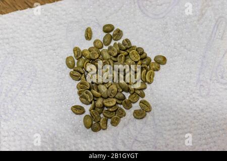 Green coffee beans on white paper towel Stock Photo