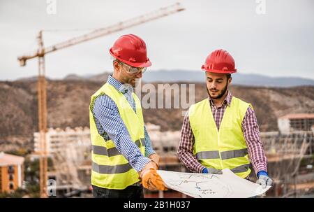 Builders on residential construction site looking the building project  - Workers are satisfied of their plan - Dealing, real estate, engineer and ind Stock Photo
