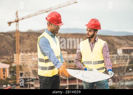 Builders on residential construction site looking the building project  - Workers are satisfied of their plan - Dealing, real estate, engineer and ind Stock Photo