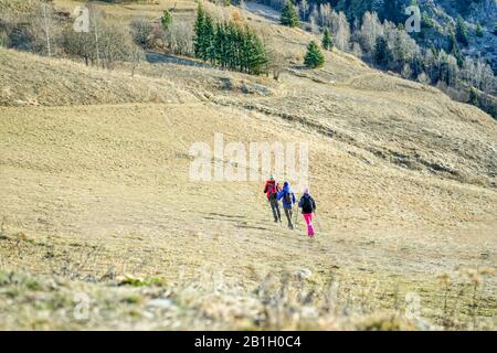 Small group of hikers friends doing trekking with backpack - Young tourist traveler reaching peak of the mountain - Spor,vacationt and healthy lifesty Stock Photo