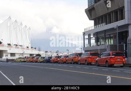 Vancouver, Canada - February 17, 2020: Line of Vancouver taxi cabs are waiting for passengers at Canada Place. Stock Photo