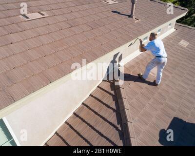 Professional Painter Using A Brush to Paint House Fascia. Stock Photo