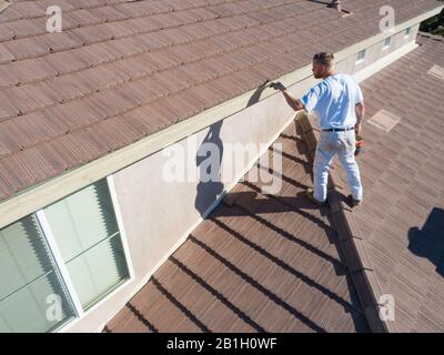 Professional Painter Using A Brush to Paint House Fascia. Stock Photo