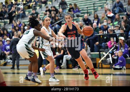 Player dribbling toward the baseline on a route toward the basket while negotiating past two defenders. USA. Stock Photo