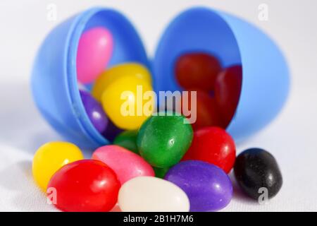 Colorful jelly beans spill out of plastic Easter eggs Stock Photo