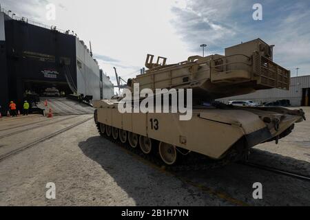 A Soldier assigned to 2nd Brigade Combat Team waits to move an M1A1 Abrams tank aboard a military transport vessel in support of DEFENDER-Europe 20 at the Port of Savannah, Ga. February 12, 2020.      DEFENDER-Europe 20 is the deployment of a division-size combat-credible force from the United States to Europe, the drawing of equipment and the movement of personnel and equipment across the theater to various training areas. U.S.-based equipment will leave from ports in four states and arrive in six European countries. This will require the support of tens of thousands of service members and ci Stock Photo