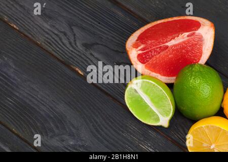 Citrus fruits slice on a black wooden background Stock Photo