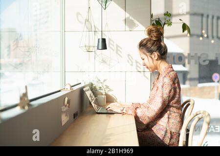 Woman using laptop in coworking office space Stock Photo